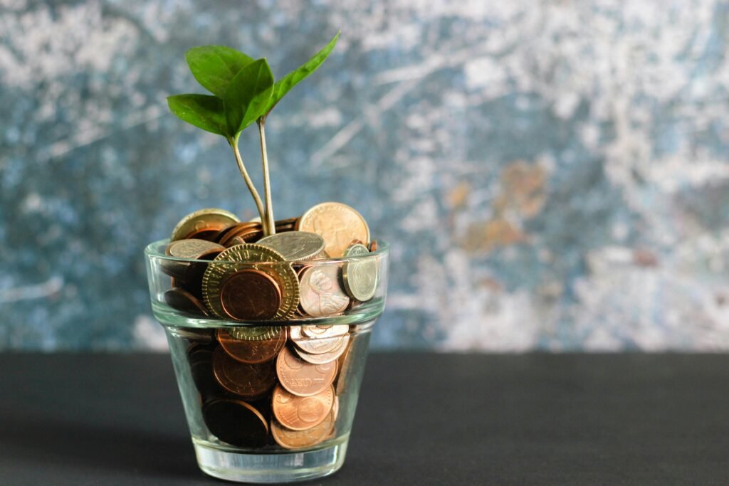 Une plante qui pousse dans un verre rempli de pièces